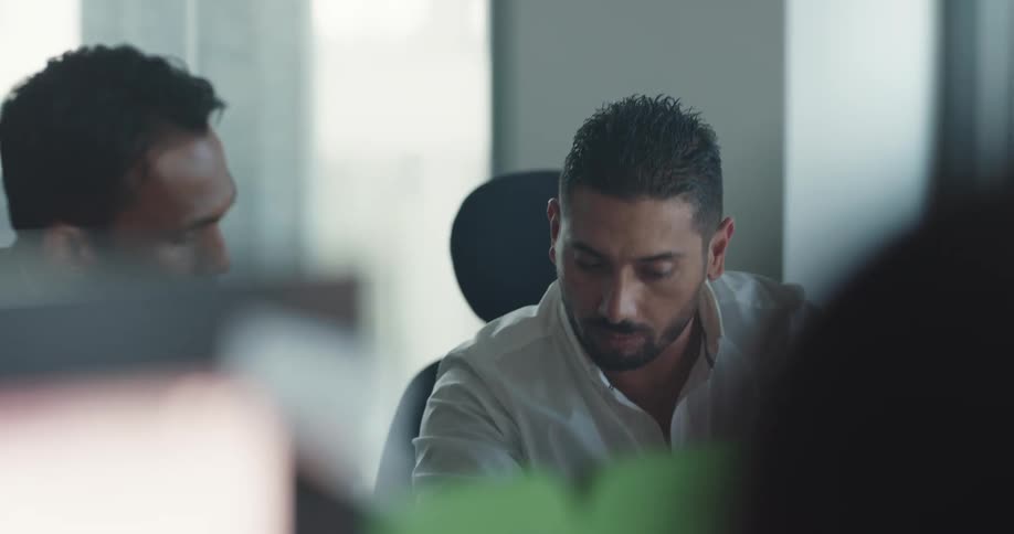 Two male coworkers are talking to each other in their office