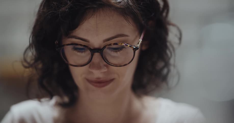 A woman is looking down concentrating as she gives a little smile