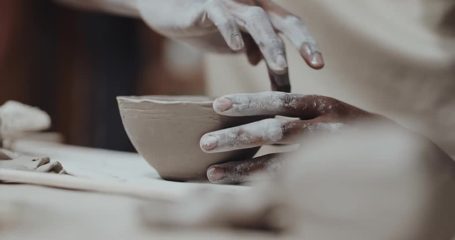 A man is making a bowl out of clay