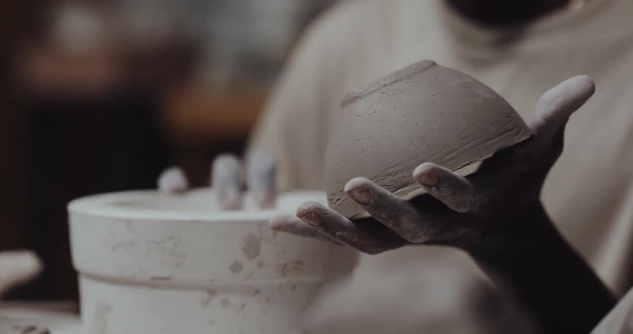 Artisan taps a mold to separate it from the freshly made clay bowl