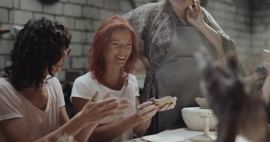 Women clap when a sculpted bowl is shown
