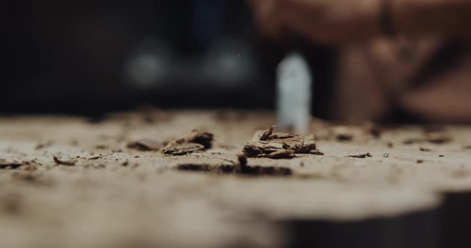 Woodcarver use metal tool to carve surface of wood