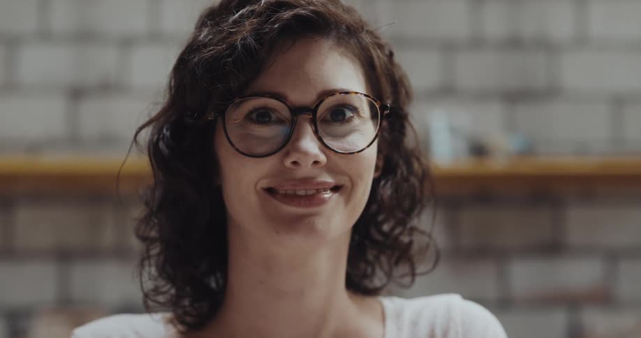 A woman is smiling and sitting in a room