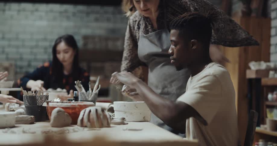 A group of people are learning how to make clay sculptures