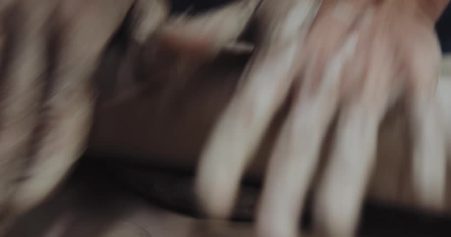A man rolls out clay with a rolling pin