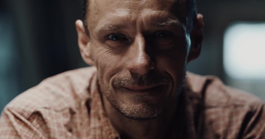 A man is smiling and standing in his house