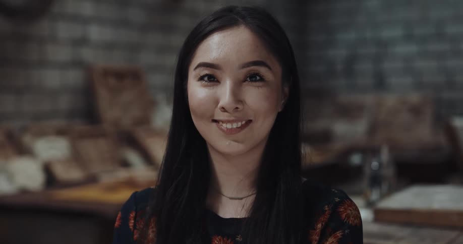 A woman is standing in her kitchen and smiling