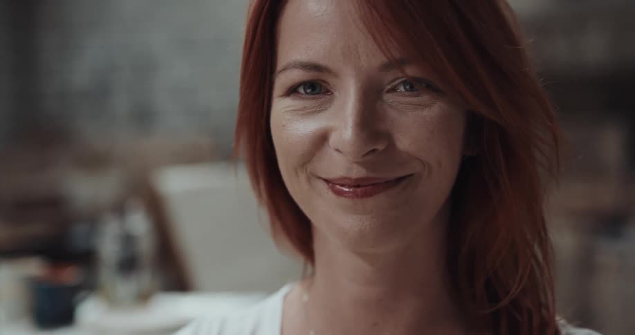 A woman is standing and smiling at the camera