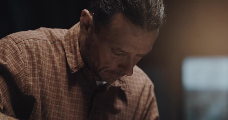 A man cuts food in his kitchen