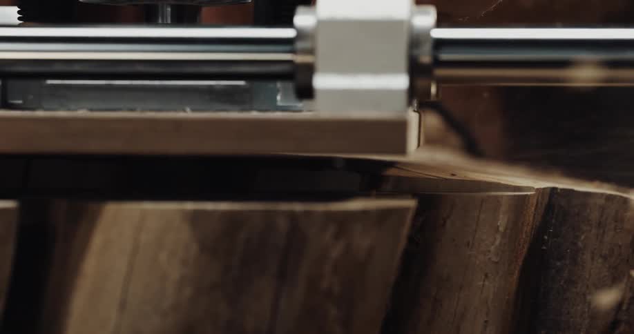 Close up of the head of a wood cutting router trimming the surface of a log