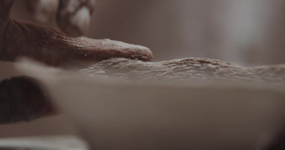 A person is sculpting a bowl