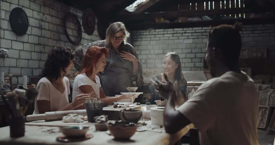 Teacher supervises the work of her students on the pottery workshop
