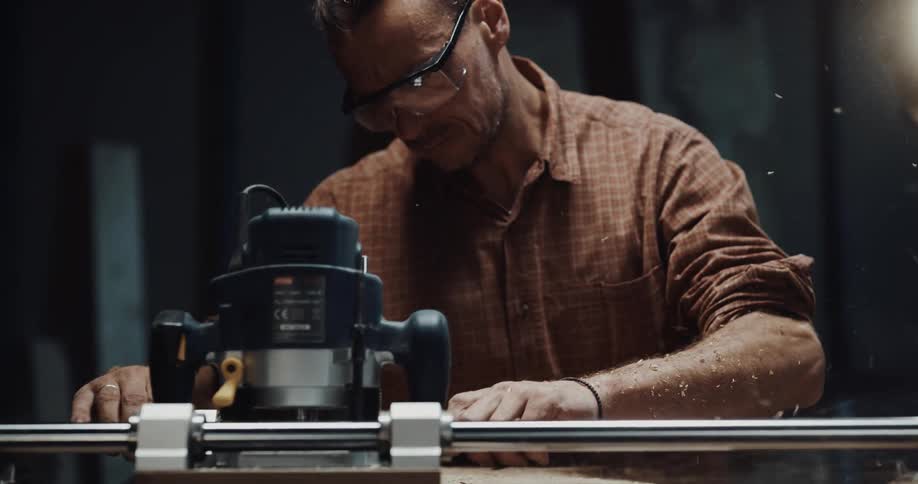 A man is using a machine to cut pieces of wood