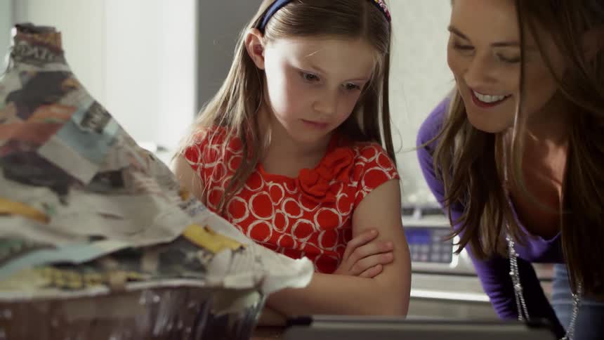 A woman and child look at a tablet together
