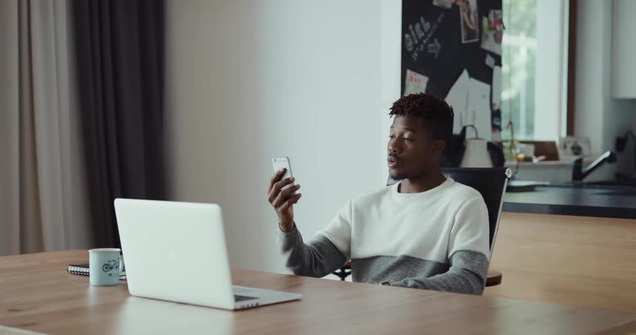 A person is sitting at a table and talking on his cellphone