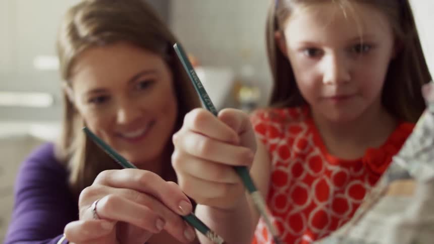 A woman and girl paint an art project