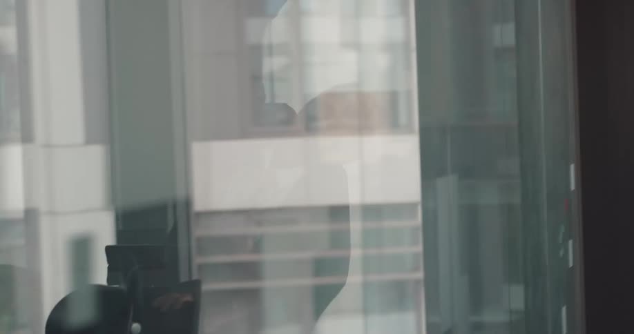 Young woman working at the office stands up from her desk to celebrate with her coworkers