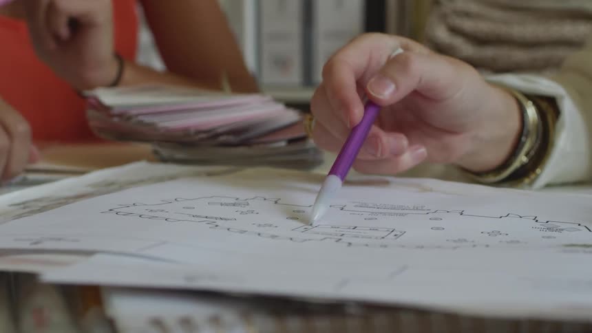 A person points out some items on a paper