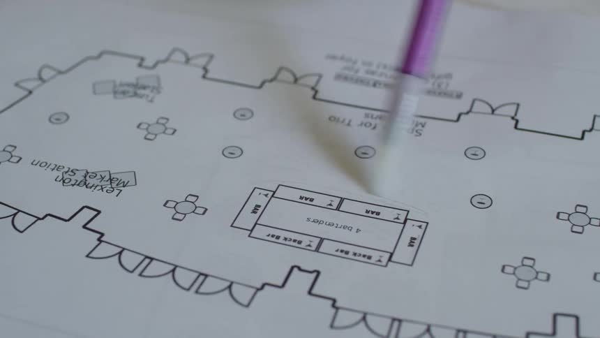 A person circles something on a floor plan