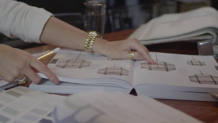 A woman points at something in a book
