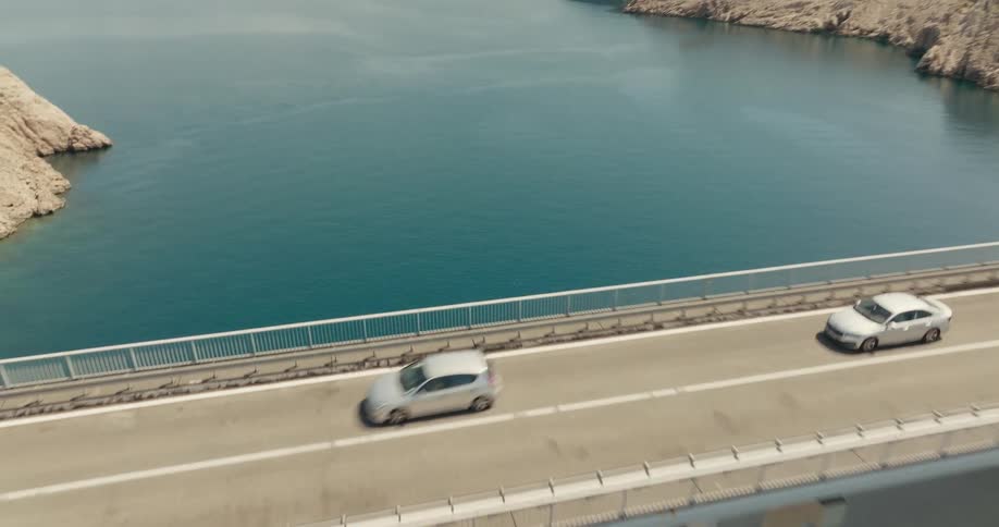 Traffic moves over a bridge that spans a river in the mountains