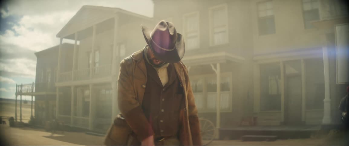 Cowboy in old west town holsters his gun then falls after being shot