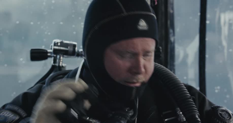 A technical scuba diver checks his regulator before a cold water dive