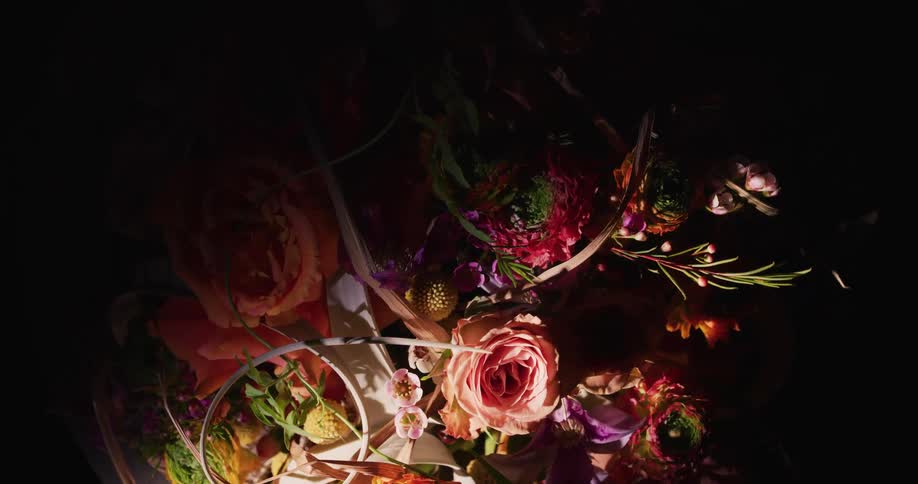 Vivid multi colored floral arrangement sits partly in shadow