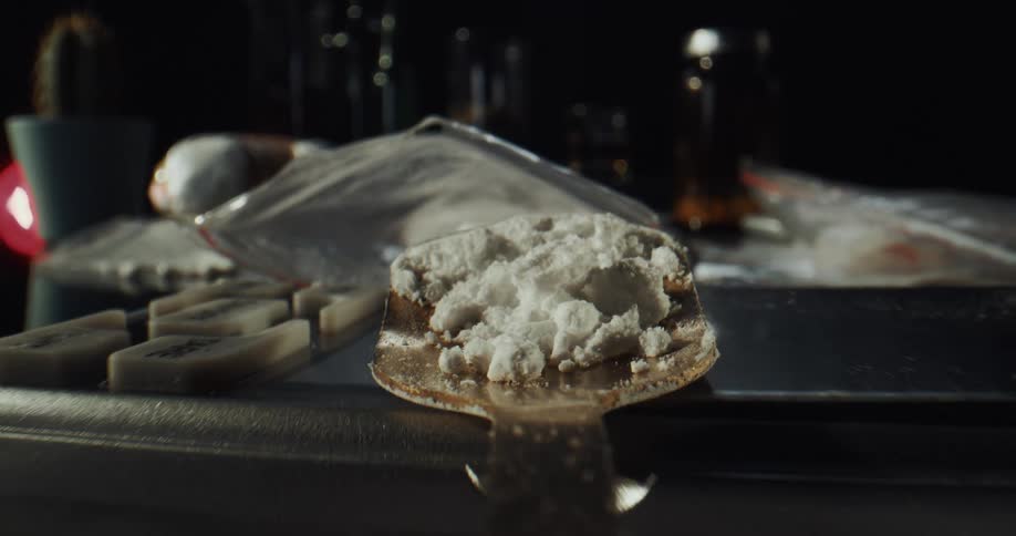 A spoon of cocaine is removed from the bag