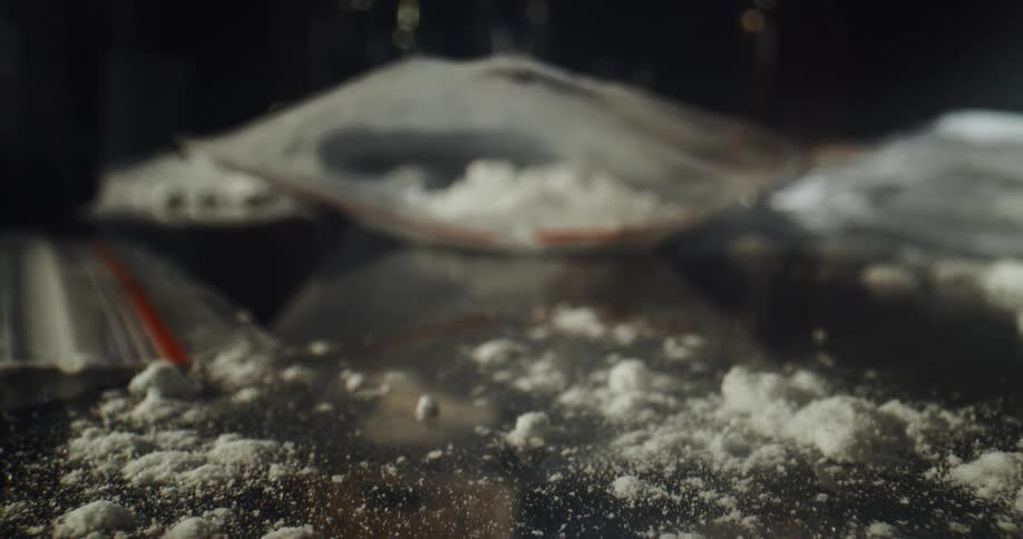 Bags of cocaine are spilled on a table