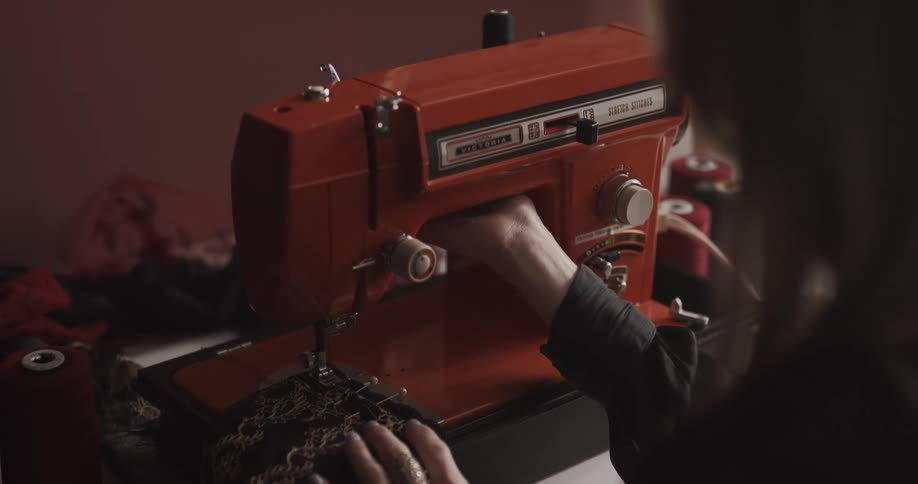 Woman sewing on a red retro sewing machine