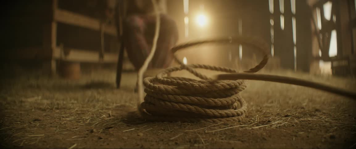 A person is tied up in a barn and panics as a rope pulls up