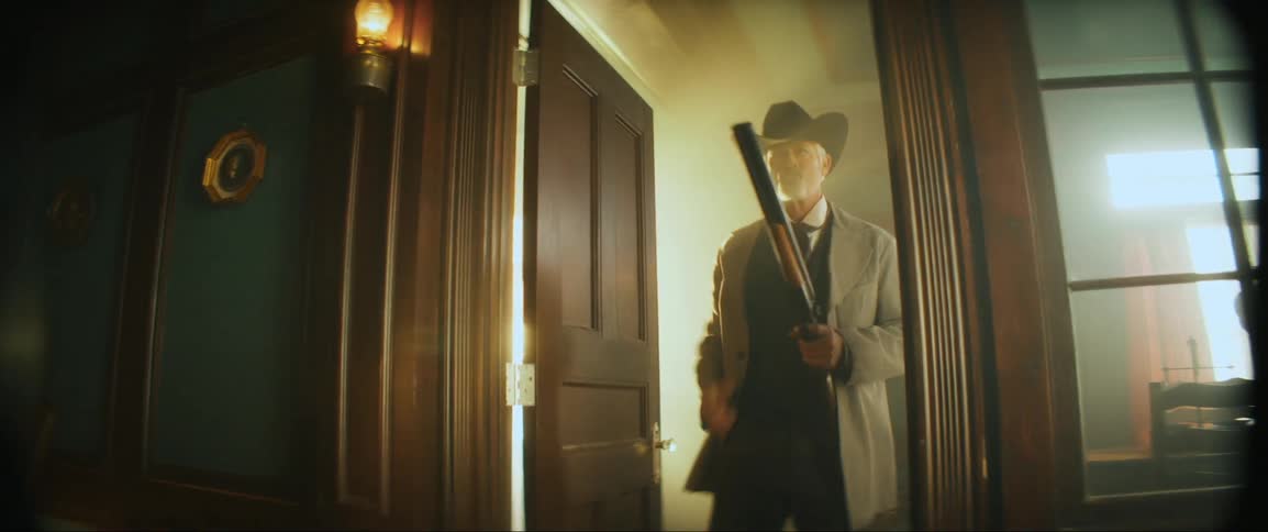A man opens the door and shoots his shotgun
