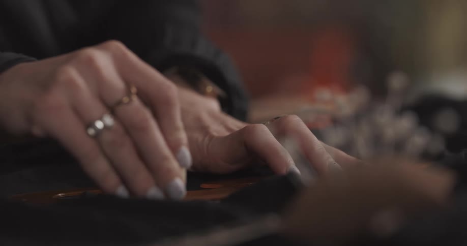 Seamstress uses tailors art curve to trace pattern piece shape onto fabric
