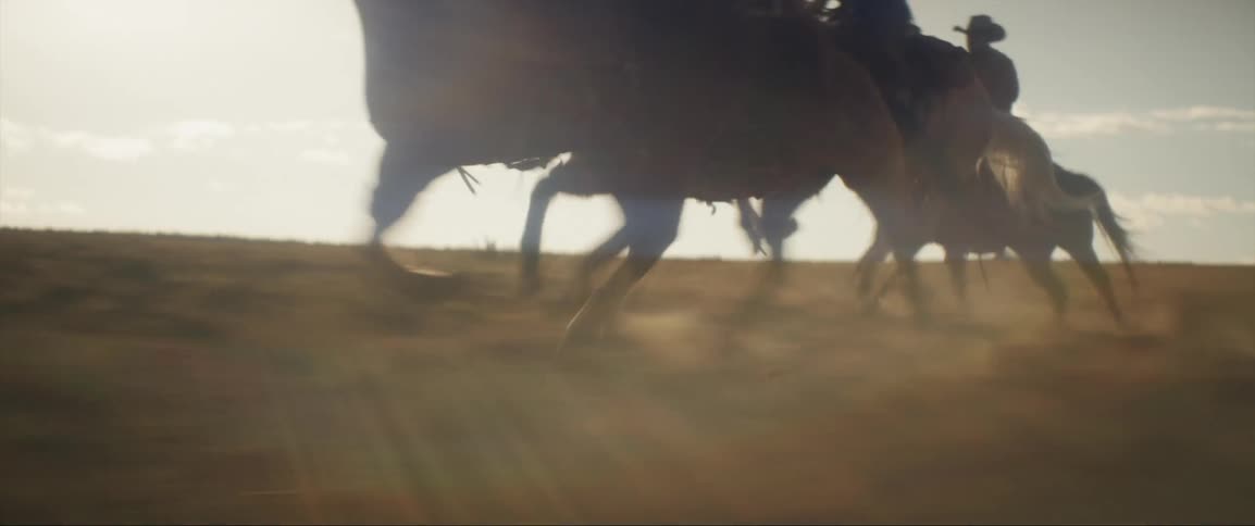 A group of people is riding horseback across a large land area