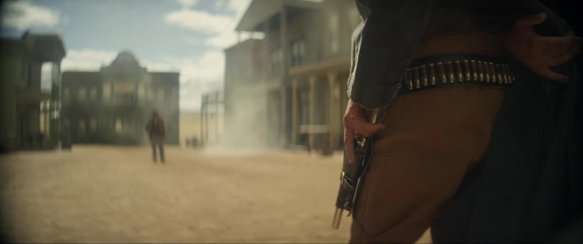 A cowboy fires his gun in a show down