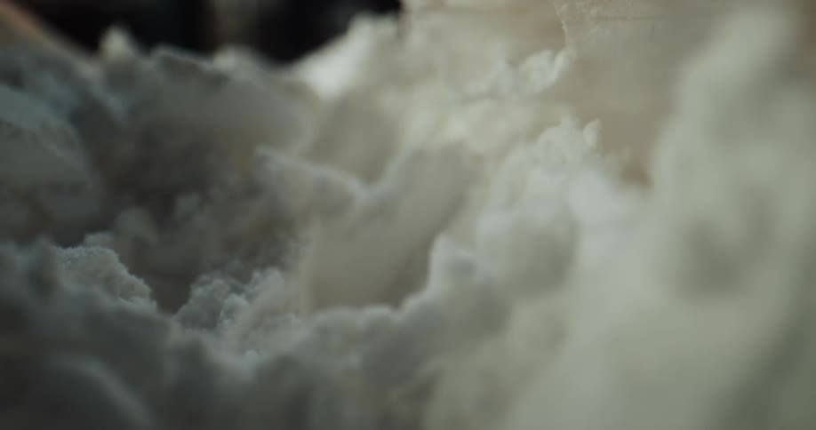 Close up of a metal spatula picking up white flour