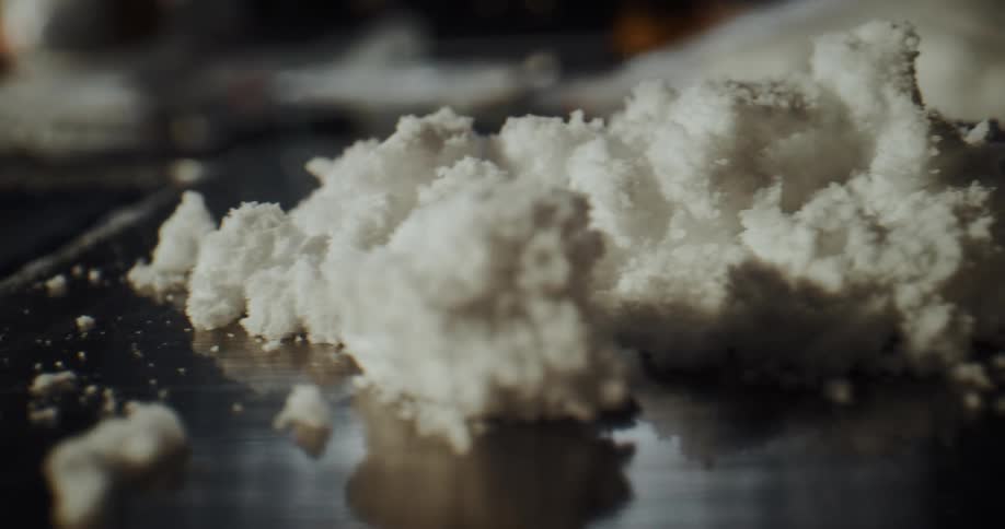 A person puts bread crumbs on a cook top