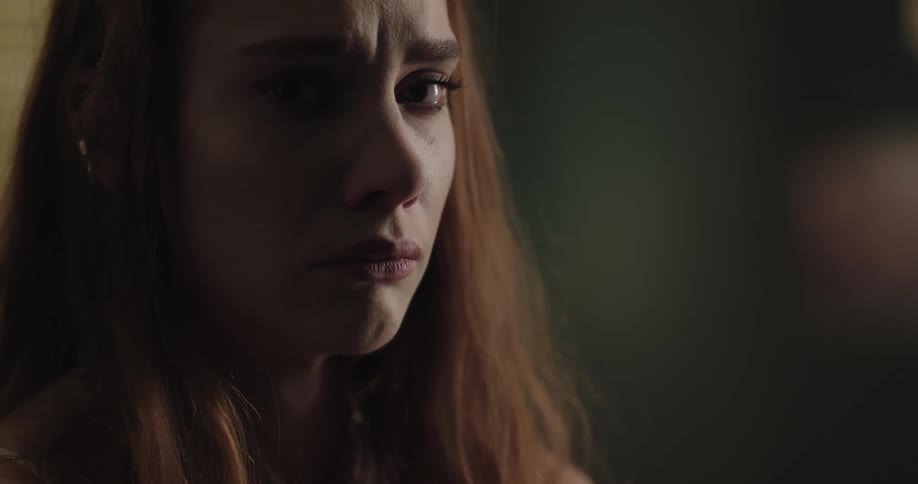 Frowning woman looks up and stares teary eyed