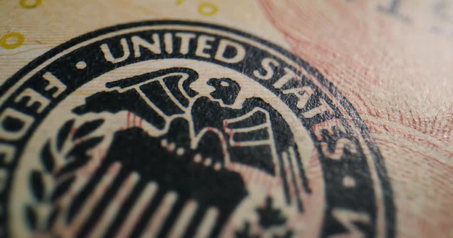 Number on american currency sits on red ink lines nearfederal reserve symbol