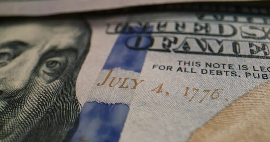 A united states one hundred dollar bill with blue security stripe and july 4th date