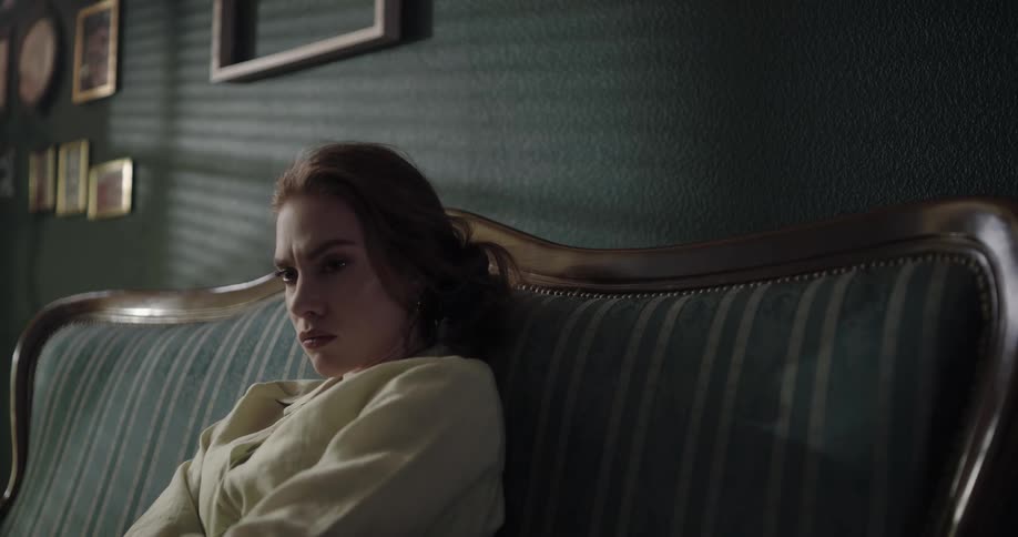 A woman sits on the couch