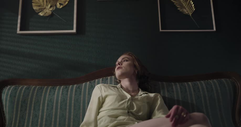 A woman is resting and sitting on an indoor sofa