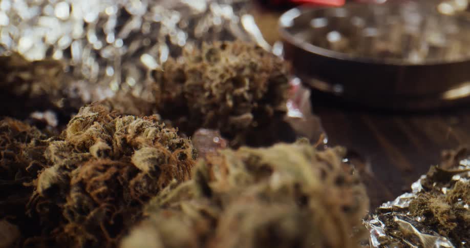 Marijuana buds on a table some wrapped in foil