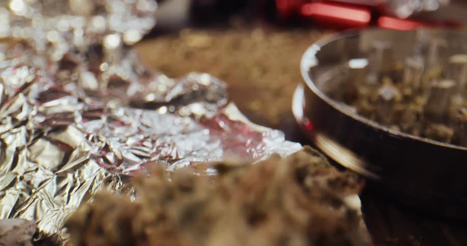 Close up of marijuana buds laying on aluminum foil over a table