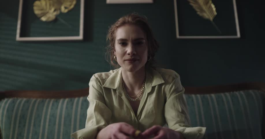 A woman is sitting on a couch and smiling