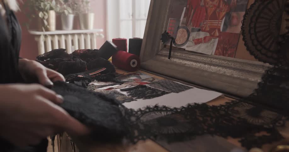 A tailor is laying fabric on the desk