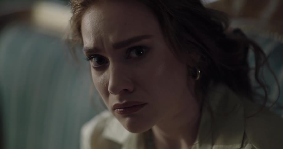 Young redhead woman sitting on the couch heavy breathing with a sad and distressed face