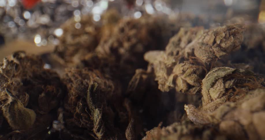 Smoke rises from dried marijuana sitting on foil