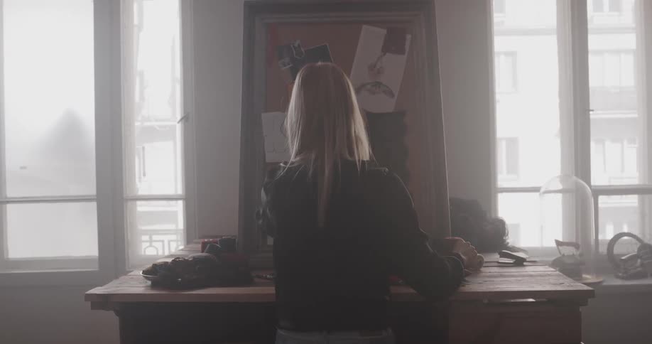 A woman is standing in her kitchen during the day